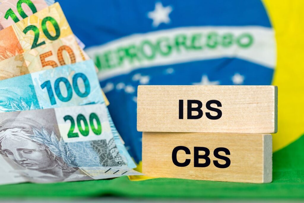 Imagem com bandeira do Brasil e dinheiro que ilustra IBS e CBS e seus papeis na reforma tributária.